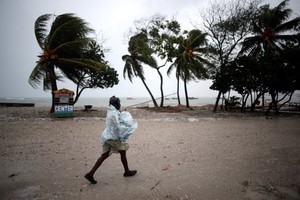 A woman protects herself from rain as Hurricane Matthew approaches in Les Cayes, Haiti, October 3, 2016. REUTERS/Andres Martinez Casares