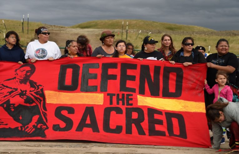 Native Americans march to a burial ground sacred site that was disturbed by bulldozers building the Dakota Access Pipeline (DAPL), near the encampment where hundreds of people have gathered to join the Standing Rock Sioux Tribe's protest of the oil pipeline that is slated to cross the Missouri River nearby, September 4, 2016 near Cannon Ball, North Dakota. Protestors were attacked by dogs and sprayed with an eye and respiratory irritant yesterday when they arrived at the site to protest after learning of the bulldozing work. / AFP / Robyn BECK (Photo credit should read ROBYN BECK/AFP/Getty Images)