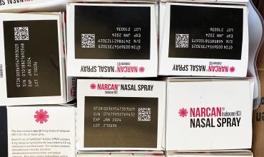 Boxes of overdose reversal drug Narcan, some upside down, stacked next to each other