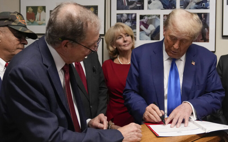 Republican presidential candidate former President Donald Trump signs papers as New Hampshire Secretary of State David Scanlan watches, to be on the 2024 Republican presidential primary ballot at the New Hampshire Statehouse, Monday, Oct. 23, 2023, in Concord, N.H. (AP Photo/Charles Krupa)