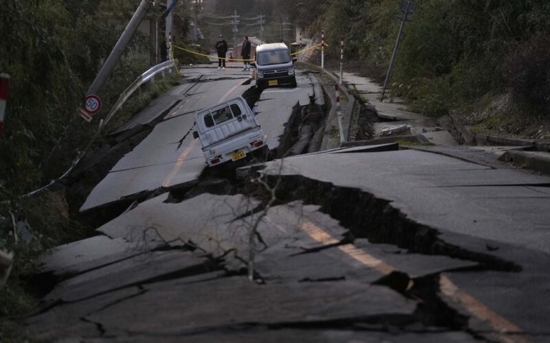 Bystanders look at damages somewhere near Noto town in the Noto peninsula facing the Sea of Japan, northwest of Tokyo, Tuesday, Jan. 2, 2024, following Monday's deadly earthquake. A series of powerful earthquakes that hit western Japan have damaged thousands of buildings, vehicles and boats. Officials warned that more quakes could lie ahead. (AP Photo/Hiro Komae)