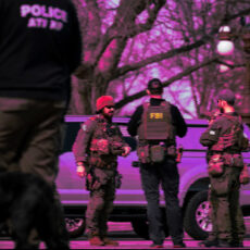 ground-level photo of ATF with a dog, FBI in tactical gear in a park in Washington DC