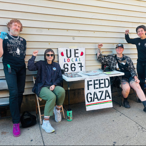photo of members of UE667 next to a table with a sign reading Feed Gaza