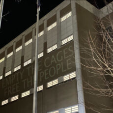 a photo from the New Years Eve 2021 Noise Demonstration at the jail with the words "Empty The Cages Free The People" projected on the outer walls of one wing