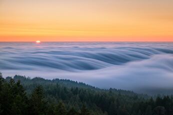 Fog rolling over green hills.