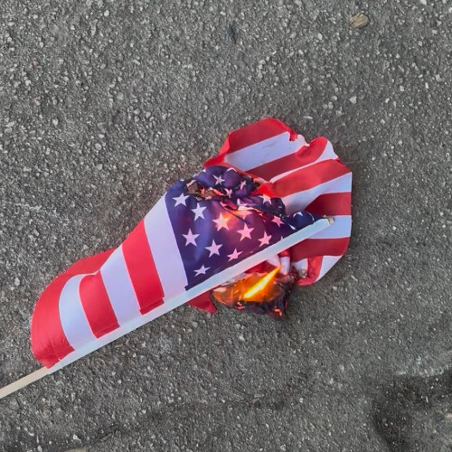 photo of a burning flag, ignited by the hot streets of Durham, NC by Oakwood Park