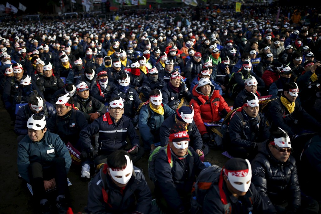 Protesters wearing masks take part in an anti-government rally in central Seoul, South Korea, December 5, 2015. image via REUTERS/Kim Hong-Ji