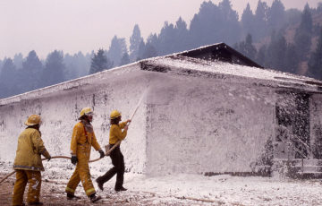 Firefighter using foam to put out a fire