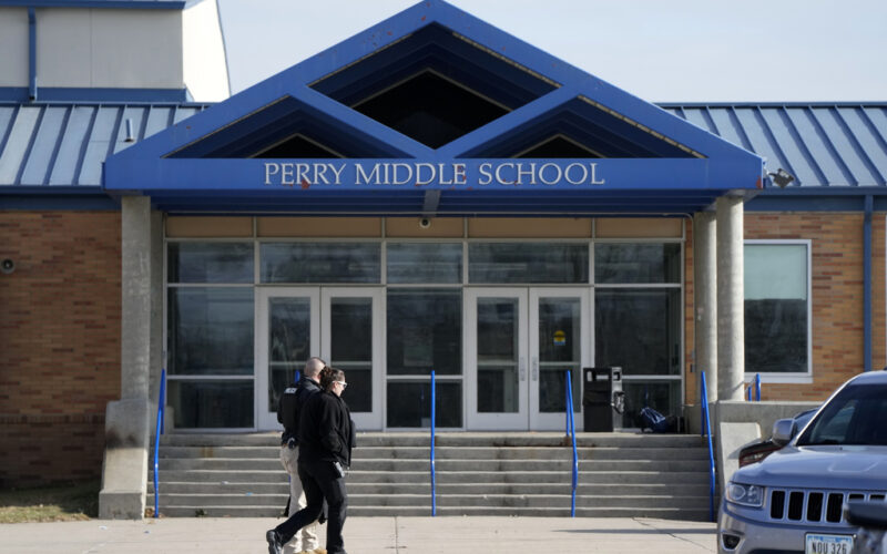 Law enforcement officials walks past the Perry Middle School entrance following a shooting at the nearby Perry High School, Thursday, Jan. 4, 2024, in Perry, Iowa. Multiple people were shot inside the school early Thursday as students prepared to start their first day of classes after their annual winter break, authorities said. (AP Photo/Charlie Neibergall)