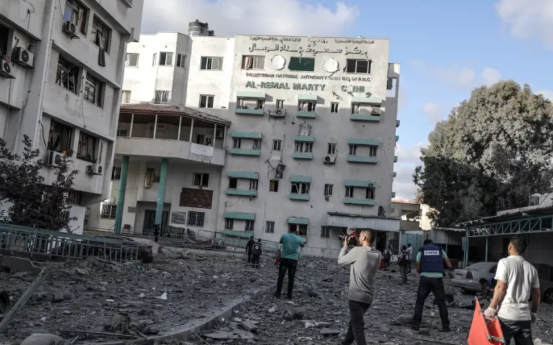 Photo of a bombed hospital in Gaza with rescue workers approaching from the street